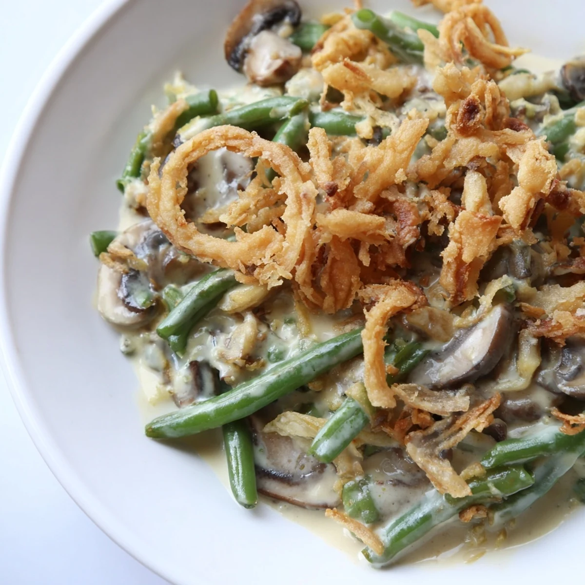 Creamy Old-School Green Bean Casserole topped with crispy fried onions for a holiday favorite.  