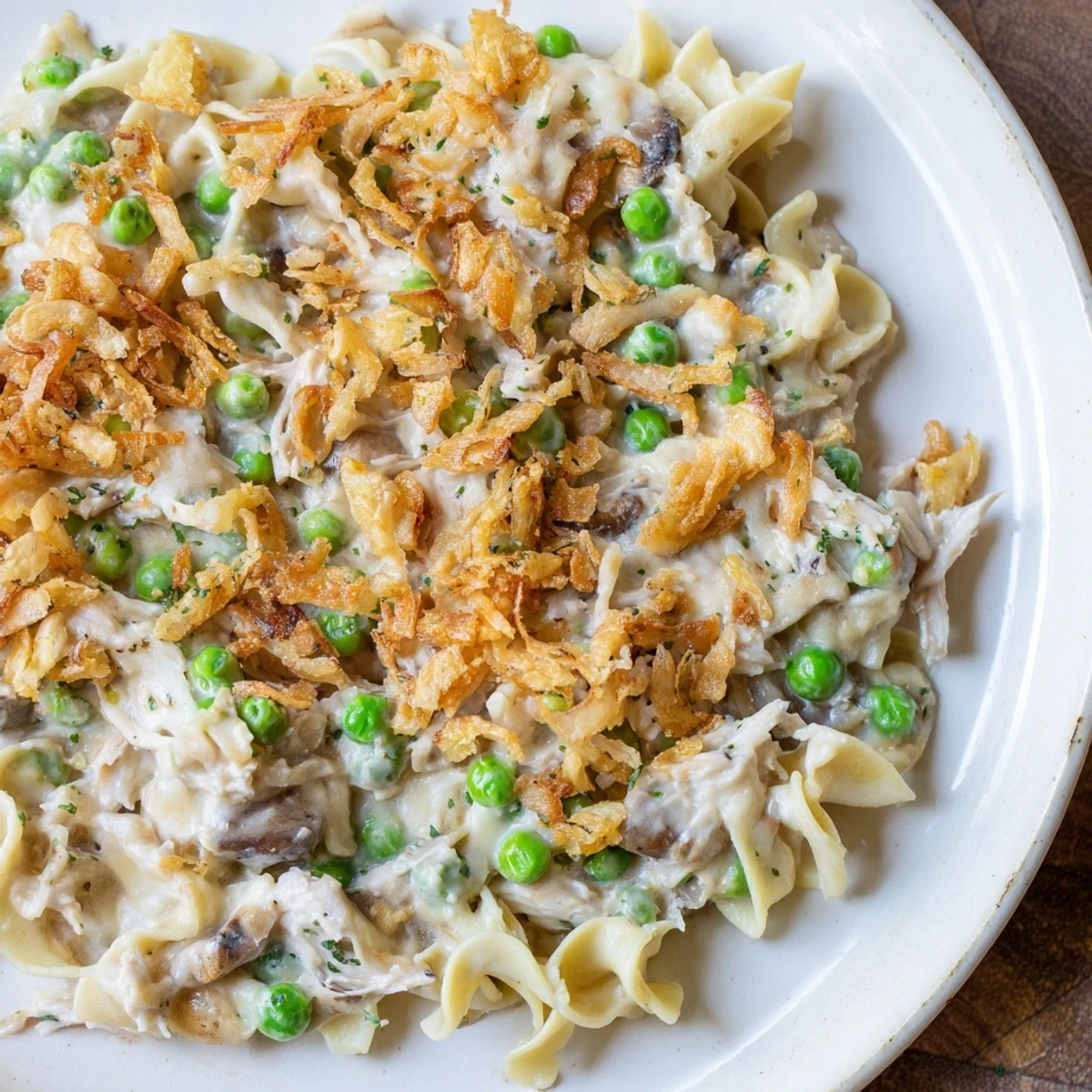 A bubbly tuna noodle casserole with a crispy golden onion topping, ready to serve and enjoy.