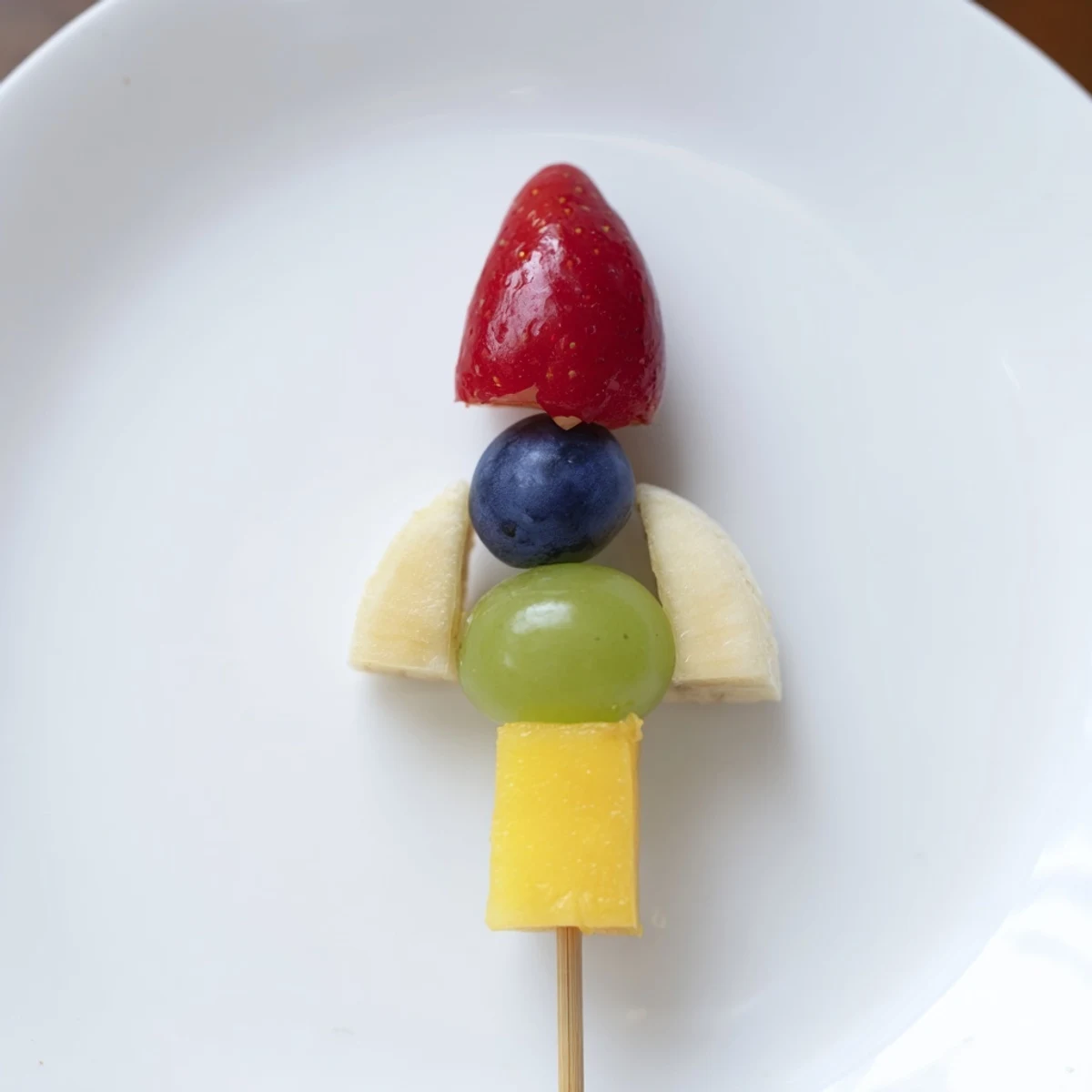 Kids will love these colorful Rocket Ship Fruit Skewers, a healthy and fun snack with pineapple flames and blueberry windows!