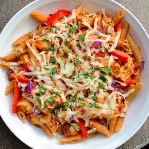 Baked Salsa Chicken Pasta, beautifully bubbly, cheese-covered, and served in a baking dish with vibrant salsa.
