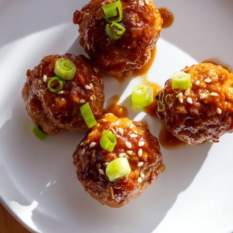 Golden, glistening Spicy Honey-Glazed Chicken Meatballs, served hot with a sticky, vibrant glaze, ready to enjoy.