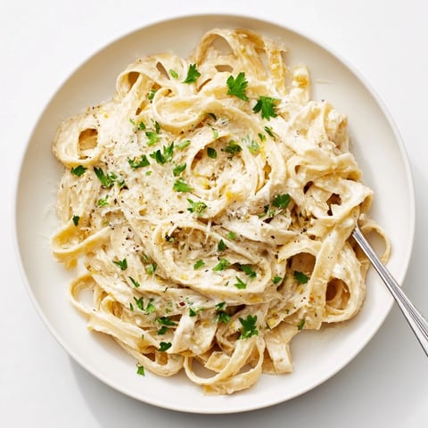 Skinny Alfredo pasta with garlic and Parmesan, a creamy, satisfying Italian-American dinner.