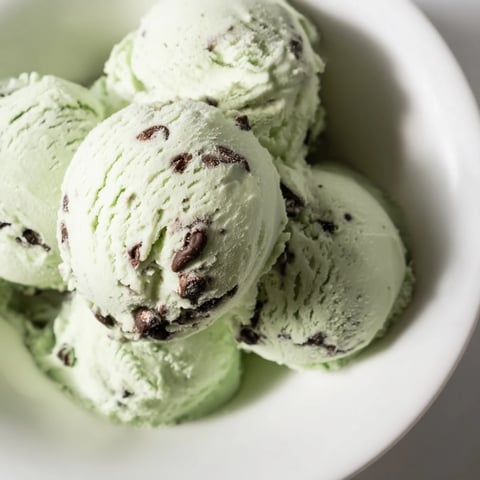 Creamy Mint Chocolate Chip Ice Cream swirled with dark chocolate chips, ready to scoop and enjoy.