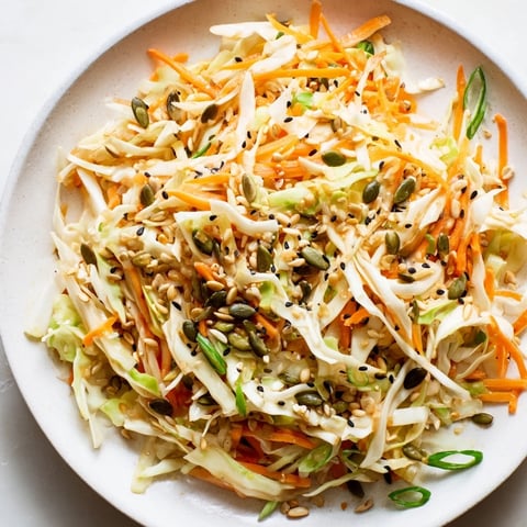 Vibrant Cabbage-Core Slaw Salad, showcasing crunchy shredded cabbage with toasted seeds and sesame dressing.