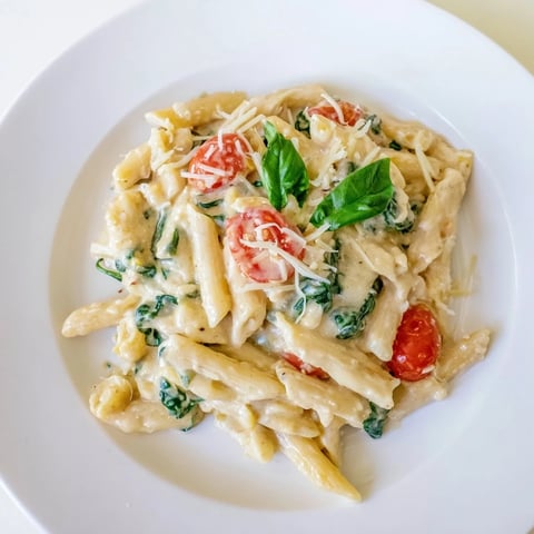 Steaming bowl of Cottage Cheese High-Protein Creamy Pasta, garnished with fresh basil leaves.