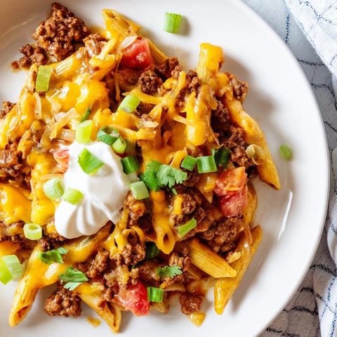 One-Pot Taco Pasta, a bubbling skillet filled with ground beef and melted cheddar cheese.