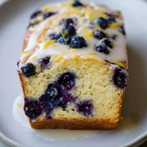 Moist Lemon Blueberry Yogurt Loaf, studded with juicy blueberries and drizzled with a sweet glaze.