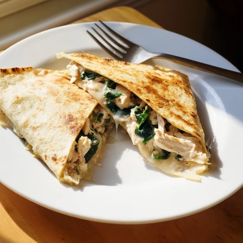 Golden, crispy Chicken and Spinach Quesadilla with melted mozzarella cheese oozing from the edges, sliced into wedges for dipping.  