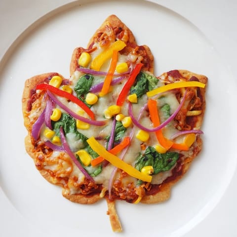 Golden crusts and melted cheese on these Fall Foliage Maple Leaf Mini Pizzas, ready to eat.