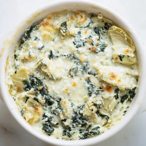 Warm, creamy Spinach Artichoke Dip, rich with Parmesan, ready to be scooped with crispy chips.
