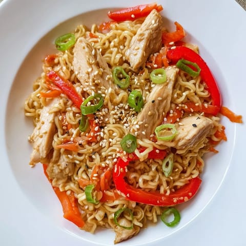 Tossing freshly cooked ramen noodles in a bold, spicy sauce with broccoli and carrots for a quick, satisfying meal.  