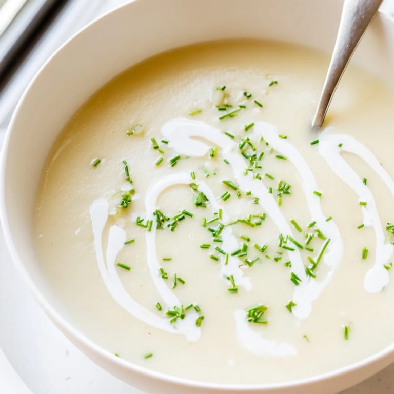 Velvety celery root bisque with a drizzle of cream, ready to enjoy with crusty bread.