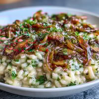 Creamy risotto with caramelized onions and mushrooms, topped with fresh parsley and Parmesan.  