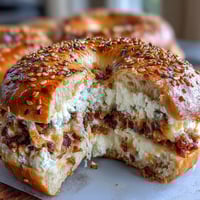 Protein bagels with Greek yogurt and everything seasoning, golden brown and sprinkled with savory seasoning, served on a wooden board.